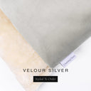 A close up detail of the corner of a Charley Chau Dog Snuggle Bed and dog Burrow Bag Dog Bed Cover with silver grey outer cover in upholstery-quality Velour and plush cream faux-fur lining with a woven brand label showing the Charley Chau logo on a white backdrop.