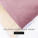 A close up detail of the corner of a Charley Chau Dog Snuggle Bed and dog Burrow Bag Dog Bed Cover with dusty rose pink outer cover in upholstery-quality Velour and plush cream faux-fur lining with a woven brand label showing the Charley Chau logo on a white backdrop.