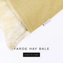 A close up detail of the corner of a Charley Chau Dog Snuggle Bed and dog Burrow Bag Dog Bed Cover with warm straw yellow outer cover in woven wool texture upholstery-quality Faroe and plush cream faux-fur lining with a woven brand label showing the Charley Chau logo on a white backdrop.