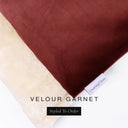 A close up detail of the corner of a Charley Chau Dog Snuggle Bed and dog Burrow Bag Dog Bed Cover with deep burgundy red outer cover in upholstery-quality Velour and plush cream faux-fur lining with a woven brand label showing the Charley Chau logo on a white backdrop.
