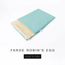 A folded spare dog bed cover to fit Charley Chau Snuggle Dog Beds and Dog Burrow Bags with pale aqua outer cover in woven wool texture upholstery-quality Faroe and plush cream faux-fur lining on a white backdrop.