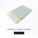 A folded spare dog bed cover to fit Charley Chau Snuggle Dog Beds and Dog Burrow Bags with pale sage green outer cover in woven wool texture upholstery-quality Faroe and plush cream faux-fur lining on a white backdrop.