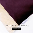 A close up detail of the corner of a Charley Chau Dog Snuggle Bed and dog Burrow Bag Dog Bed Cover with deep purple outer cover in upholstery-quality Velour and plush cream faux-fur lining with a woven brand label showing the Charley Chau logo on a white backdrop.