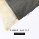 A close up detail of the corner of a Charley Chau Dog Snuggle Bed and dog Burrow Bag Dog Bed Cover with dark grey outer cover in woven wool texture upholstery-quality Faroe and plush cream faux-fur lining with a woven brand label showing the Charley Chau logo on a white backdrop.