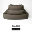 Three sizes of the Bliss Bolster Dog Bed in a deep olive brown 'BARK' Faroe fabric nested together, showing this long lasting dog bed with sides in Small, Medium and Large; a hard-wearing bolster dog bed and high-wall dog bed for everyday comfort.
