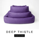Three sizes of the Bliss Bolster Dog Bed in a rich deep purple 'DEEP THISTLE' Faroe fabric nested together, showing this long lasting dog bed with sides in Small, Medium and Large; a hard-wearing bolster dog bed and high-wall dog bed for everyday comfort.