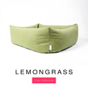 Close-up corner view of a soft sage green Bliss Bolster Dog Bed in 'LEMONGRASS' Faroe fabric with a pink 'Core Collection' label, showing the tall walls of this long lasting dog bed with sides; a durable bolster dog bed and high-wall dog bed built to last.