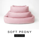 Three sizes of the Bliss Bolster Dog Bed in a soft blush pink 'SOFT PEONY' Faroe fabric nested together, showing this long lasting dog bed with sides in Small, Medium and Large; a hard-wearing bolster dog bed and high-wall dog bed for everyday comfort.