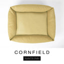 Top-down view of the Bliss Bolster Dog Bed in a warm golden mustard 'CORNFIELD' Faroe fabric, showing the raised sides and deep cushioned base of this long lasting dog bed with sides; a comfortable bolster dog bed and high-wall dog bed for everyday use.