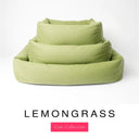 Three sizes of the Bliss Bolster Dog Bed in a soft sage green 'LEMONGRASS' Faroe fabric nested together, showing this long lasting dog bed with sides in Small, Medium and Large; a hard-wearing bolster dog bed and high-wall dog bed for everyday comfort.