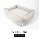 A soft off-white cream Bliss Bolster Dog Bed in 'VELLUM' Faroe fabric shown from an angle on a white background, highlighting the tall sides of this long lasting dog bed with sides; a stylish bolster dog bed and high-wall dog bed for dogs of all sizes.