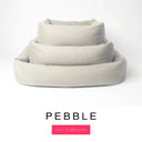 Three sizes of the Bliss Bolster Dog Bed in a warm stone grey 'PEBBLE' Faroe fabric nested together, showing this long lasting dog bed with sides in Small, Medium and Large; a hard-wearing bolster dog bed and high-wall dog bed for everyday comfort.