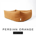 Close-up corner view of a warm amber orange Bliss Bolster Dog Bed in 'PERSIAN ORANGE' Faroe fabric with a black 'Styled To Order' label, showing the tall walls of this long lasting dog bed with sides; a durable bolster dog bed and high-wall dog bed built to last.