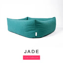Close-up corner view of a deep teal green Bliss Bolster Dog Bed in 'JADE' Faroe fabric with a pink 'Core Collection' label, showing the tall walls of this long lasting dog bed with sides; a durable bolster dog bed and high-wall dog bed built to last.