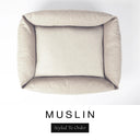 Top-down view of the Bliss Bolster Dog Bed in a soft warm cream 'MUSLIN' Faroe fabric, showing the raised sides and deep cushioned base of this long lasting dog bed with sides; a comfortable bolster dog bed and high-wall dog bed for everyday use.