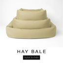 Three sizes of the Bliss Bolster Dog Bed in a warm golden oat 'HAY BALE' Faroe fabric nested together, showing this long lasting dog bed with sides in Small, Medium and Large; a hard-wearing bolster dog bed and high-wall dog bed for everyday comfort.