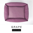 Top-down view of the Bliss Bolster Dog Bed in a dusky mauve-purple 'GRAPE' Faroe fabric, showing the raised sides and deep cushioned base of this long lasting dog bed with sides; a comfortable bolster dog bed and high-wall dog bed for everyday use.