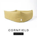 Close-up corner view of a warm golden mustard Bliss Bolster Dog Bed in 'CORNFIELD' Faroe fabric with a black 'Styled To Order' label, showing the tall walls of this long lasting dog bed with sides; a durable bolster dog bed and high-wall dog bed built to last.