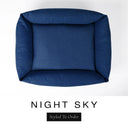 Top-down view of the Bliss Bolster Dog Bed in a deep navy blue 'NIGHT SKY' Faroe fabric, showing the raised sides and deep cushioned base of this long lasting dog bed with sides; a comfortable bolster dog bed and high-wall dog bed for everyday use.