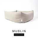 Close-up corner view of a soft warm cream Bliss Bolster Dog Bed in 'MUSLIN' Faroe fabric with a black 'Styled To Order' label, showing the tall walls of this long lasting dog bed with sides; a durable bolster dog bed and high-wall dog bed built to last.
