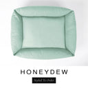 Top-down view of the Bliss Bolster Dog Bed in a pale sage green 'HONEYDEW' Faroe fabric, showing the raised sides and deep cushioned base of this long lasting dog bed with sides; a comfortable bolster dog bed and high-wall dog bed for everyday use.