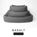 Three sizes of the Bliss Bolster Dog Bed in a dark charcoal grey 'BASALT' Faroe fabric nested together, showing this long lasting dog bed with sides in Small, Medium and Large; a hard-wearing bolster dog bed and high-wall dog bed for everyday comfort.
