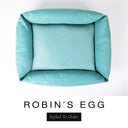 Top-down view of the Bliss Bolster Dog Bed in a soft powder blue 'ROBIN'S EGG' Faroe fabric, showing the raised sides and deep cushioned base of this long lasting dog bed with sides; a comfortable bolster dog bed and high-wall dog bed for everyday use.