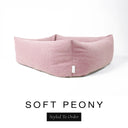 Close-up corner view of a soft blush pink Bliss Bolster Dog Bed in 'SOFT PEONY' Faroe fabric with a black 'Styled To Order' label, showing the tall walls of this long lasting dog bed with sides; a durable bolster dog bed and high-wall dog bed built to last.