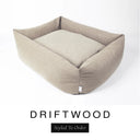 A warm sandy taupe Bliss Bolster Dog Bed in 'DRIFTWOOD' Faroe fabric shown from an angle on a white background, highlighting the tall sides of this long lasting dog bed with sides; a stylish bolster dog bed and high-wall dog bed for dogs of all sizes.