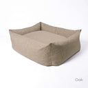 A  high-sided dog bolster bed in a beige woven upholstery fabric by Charley Chau on a white backdrop.  
