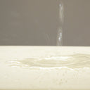 Close up of water splashing onto a cream colour Anti-Micorbial Waterproof Dog Bed Liner.